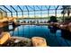 Beautiful screened pool with rock waterfall feature and view of the lake at 273 Portofino Dr, North Venice, FL 34275