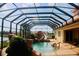 Resort style covered pool and spa with waterfalls and slide overlooking lake at 273 Portofino Dr, North Venice, FL 34275