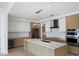 Open concept kitchen boasts quartz counters, stainless steel appliances, and custom lighting at 301 Quay Commons # 1411, Sarasota, FL 34236