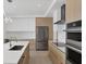 Modern kitchen with stainless steel appliances, custom cabinetry, and center island at 301 Quay Commons # 1411, Sarasota, FL 34236