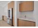 Modern kitchen featuring stainless steel appliances, light wood cabinetry, and marble countertops at 301 Quay Commons # 1411, Sarasota, FL 34236