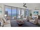 Bright living room boasts expansive windows offering stunning waterfront views, neutral furniture, and chic decor at 301 Quay Commons # 1411, Sarasota, FL 34236