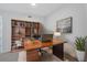 Home office featuring a wood desk, bookcase, leather chair, neutral carpet and wall art at 301 Quay Commons # 1411, Sarasota, FL 34236
