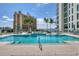 Community pool with lounge chairs, palm trees, and building views make this a great place to relax at 301 Quay Commons # 1411, Sarasota, FL 34236