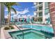 Inviting pool and spa area surrounded by lounge chairs and lush tropical landscaping at 301 Quay Commons # 1411, Sarasota, FL 34236