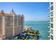 Balcony view showcasing a resort complex with a pool area and clear blue water, blending luxury and relaxation at 301 Quay Commons # 1411, Sarasota, FL 34236