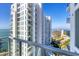 Balcony view highlighting the building's architecture and the nearby beach resort, with blue water and sky at 301 Quay Commons # 1411, Sarasota, FL 34236