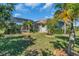 Beautiful backyard with tropical plants, screened-in pool, and manicured lawn at 3336 Lakeside Cir, Parrish, FL 34219