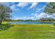 Expansive green backyard leading to a serene lake at 3336 Lakeside Cir, Parrish, FL 34219