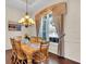 Formal dining room featuring hardwood floors, chandelier lighting, and a large window with draperies at 3336 Lakeside Cir, Parrish, FL 34219