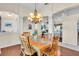 Dining room with hardwood floors, wood table set, chandelier, and open concept living at 3336 Lakeside Cir, Parrish, FL 34219