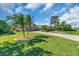 Beautifully landscaped front yard with mature palms and a paver driveway at 3336 Lakeside Cir, Parrish, FL 34219