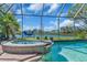 Relax in the luxurious hot tub with custom stonework and a waterfall feature overlooking the backyard lake at 3336 Lakeside Cir, Parrish, FL 34219