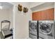 Well-equipped laundry room with modern washer and dryer, and storage cabinets for convenience at 3336 Lakeside Cir, Parrish, FL 34219