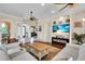 Bright, open living room with a modern fireplace, flat screen TV, ceiling fans and adjoining dining area at 3336 Lakeside Cir, Parrish, FL 34219