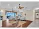 Open concept living room featuring ceiling fans, hardwood floors, and sliding glass doors to the pool area at 3336 Lakeside Cir, Parrish, FL 34219
