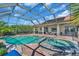 Beautiful screened pool with spa, patio, and lush landscaping perfect for outdoor relaxation and entertaining at 3336 Lakeside Cir, Parrish, FL 34219