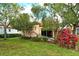 Relaxing backyard featuring a lush lawn, colorful foliage, and a screened-in porch at 3814 Mira Lago Dr, Sarasota, FL 34238