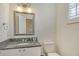 Powder room with a granite vanity, stainless steel faucet, and a decorative mirror with ornate lighting at 3814 Mira Lago Dr, Sarasota, FL 34238