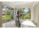 Well-lit exercise room with tile floor, elliptical trainer, and large windows offering green backyard views at 3814 Mira Lago Dr, Sarasota, FL 34238