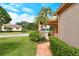Home with lush landscaping, brick walkway, and partial lake view at 3814 Mira Lago Dr, Sarasota, FL 34238