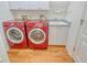 Laundry room featuring a stainless steel sink and modern red LG washer and dryer set on hardwood floors at 3814 Mira Lago Dr, Sarasota, FL 34238