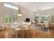 Bright and airy living room with dining area, wood floors, ceiling fan, and large windows with plantation shutters at 3814 Mira Lago Dr, Sarasota, FL 34238