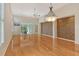 A spacious, bright living area featuring light wood floors, ceiling fan, and an adjacent exercise area at 3814 Mira Lago Dr, Sarasota, FL 34238