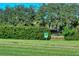 Green and lush foliage surrounds a pond view. Signage at the Crane Lake private property at 3814 Mira Lago Dr, Sarasota, FL 34238