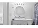 Well-lit bathroom featuring a round mirror, granite countertop, and modern vanity at 4126 Heron Way # B113, Bradenton, FL 34205