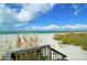 Stairway to a white sandy beach with sea oats and a view of the ocean at 4320 Falmouth Dr # 301, Longboat Key, FL 34228