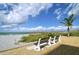 Beachfront scene with benches overlooking the white sand, sea oats and calm blue ocean at 4320 Falmouth Dr # 301, Longboat Key, FL 34228