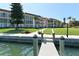 Beautiful waterfront condo building with dock, lush landscaping, and water views on a clear day at 4320 Falmouth Dr # 301, Longboat Key, FL 34228