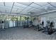 On-site fitness center with workout equipment, ceiling fans, and natural light from the adjacent glass-enclosed porch at 4320 Falmouth Dr # 301, Longboat Key, FL 34228