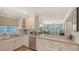 Bright kitchen featuring white cabinetry, stainless steel appliances, and a view into the living room at 4320 Falmouth Dr # 301, Longboat Key, FL 34228