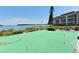 Well-manicured putting green with a waterfront backdrop and nearby condo building, perfect for golfers at 4320 Falmouth Dr # 301, Longboat Key, FL 34228