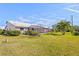 Expansive backyard showcasing lush green lawn, mature landscaping, and a screened in patio at 5388 Pamela Wood Way # 8, Sarasota, FL 34233