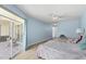 Bright bedroom with light blue walls, ceiling fan, and sliding glass doors to the outside patio at 5388 Pamela Wood Way # 8, Sarasota, FL 34233