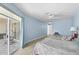 Bright bedroom with light blue walls, ceiling fan, and sliding glass doors to the outside patio at 5388 Pamela Wood Way # 8, Sarasota, FL 34233