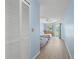 Hallway view of a spacious bedroom featuring two beds, light blue walls, and a sliding glass door to the outside at 5388 Pamela Wood Way # 8, Sarasota, FL 34233