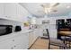 Modern kitchen with white cabinets, stainless steel appliances, and wood-look flooring at 5388 Pamela Wood Way # 8, Sarasota, FL 34233