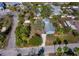 Aerial view of a single story home with a metal roof, mature landscaping, driveway and quiet neighborhood streets at 651 Fox St, Longboat Key, FL 34228