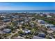 An aerial shot highlighting a coastal home bordered in white, near the ocean and surrounded by lush greenery at 651 Fox St, Longboat Key, FL 34228