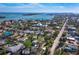 Aerial view of a coastal community with lush vegetation, homes, roadways and an ocean view at 651 Fox St, Longboat Key, FL 34228