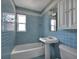 Bathroom featuring blue tiles, pedestal sink, and window with natural light at 651 Fox St, Longboat Key, FL 34228
