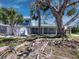 Two-story home with white trim, landscaping, a white fence, and mature palm trees at 651 Fox St, Longboat Key, FL 34228