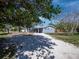 Charming blue two-story home featuring white trim, a gravel driveway, and mature trees at 651 Fox St, Longboat Key, FL 34228