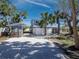Charming blue two-story home featuring white trim, a gravel driveway, and mature trees at 651 Fox St, Longboat Key, FL 34228