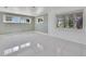 Spacious living room with light green walls, large windows, and sleek white tile flooring at 651 Fox St, Longboat Key, FL 34228