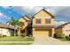 Charming two-story home with a lush green lawn, a palm tree, and red shutters on the windows at 14318 Fissore Blvd, Wimauma, FL 33598